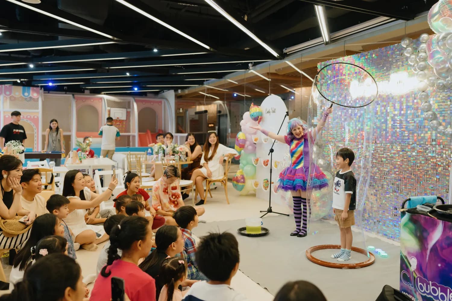 A bubble-show entertainer delighting children and families at a celebration in Our Second Home